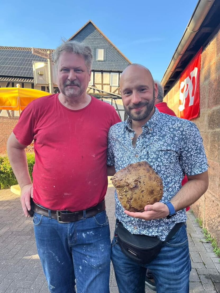 Peter Hesse überreicht Sebastian Sack ein frisches Brot